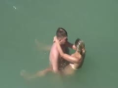 Horny pair having sex in the water on a nudist beach 